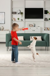 Photo of Little boy playing with his cute dog at home. Adorable pet