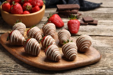 Delicious chocolate covered strawberries on wooden table