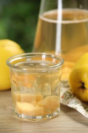 Delicious quince drink and fresh fruits on wooden table, closeup
