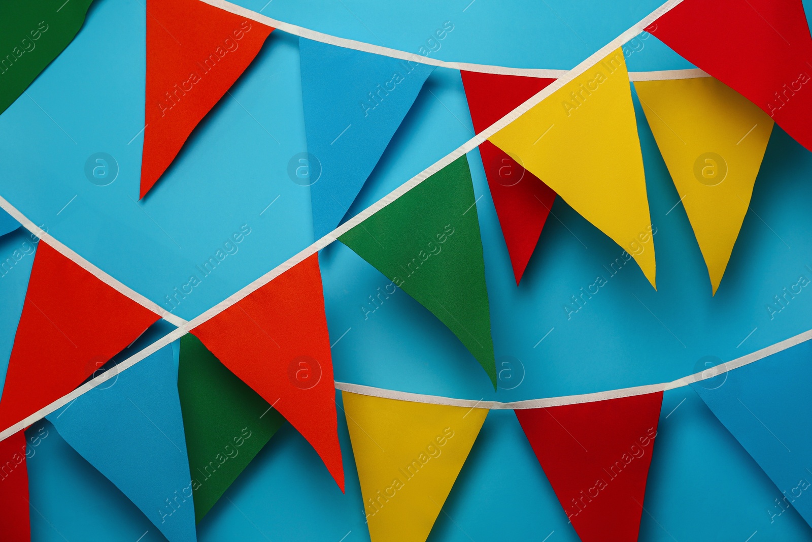 Photo of Buntings with colorful triangular flags on light blue background