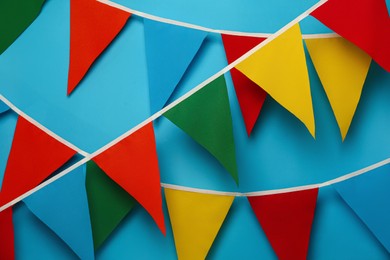 Buntings with colorful triangular flags on light blue background