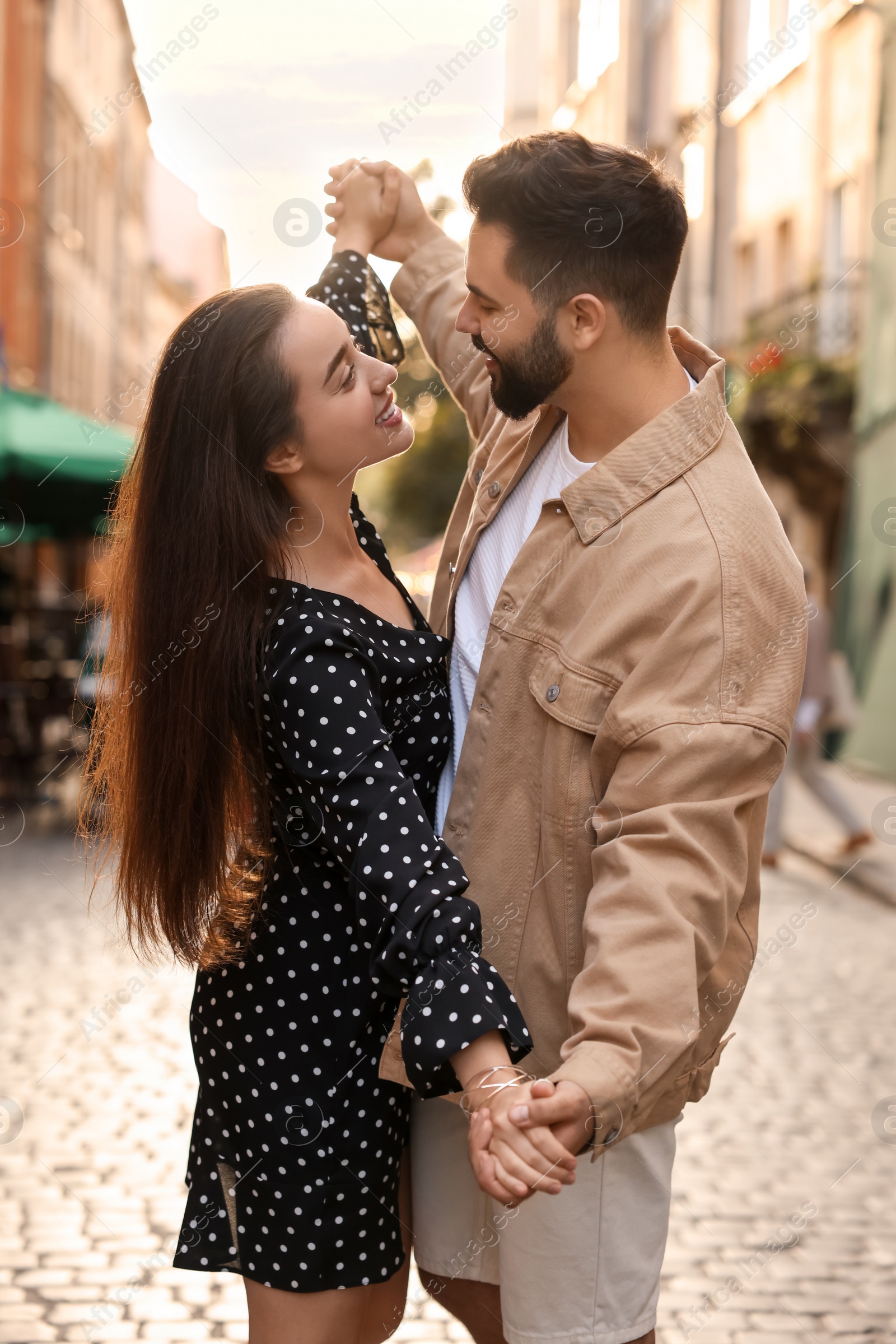 Photo of Lovely couple dancing together on city street