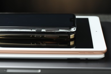 Photo of Stack of electronic devices on black background, closeup