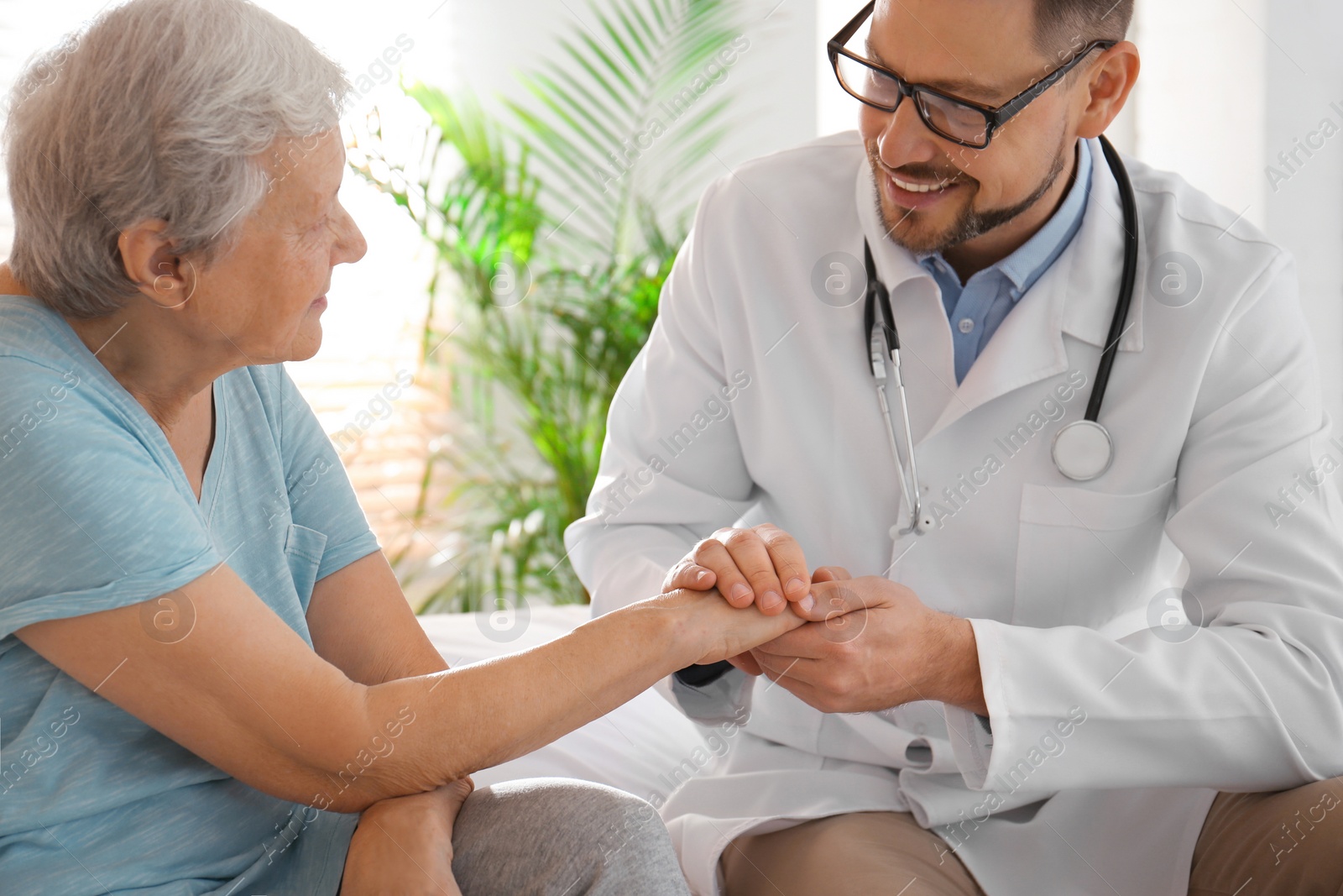 Photo of Doctor visiting senior patient in modern hospital