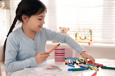 Photo of Cute child coloring drawing at table in room