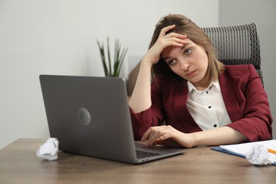 Photo of Sad businesswoman working at wooden table in office