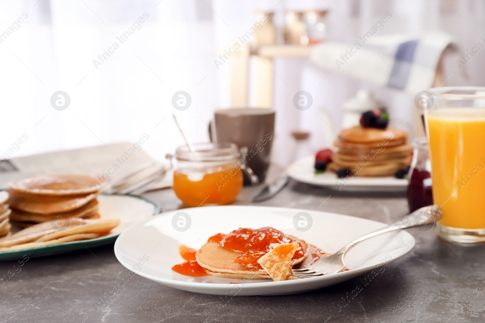 Photo of Delicious pancakes with jam served for breakfast on table