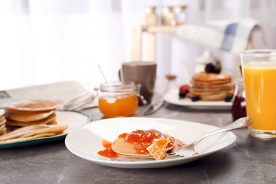 Photo of Delicious pancakes with jam served for breakfast on table