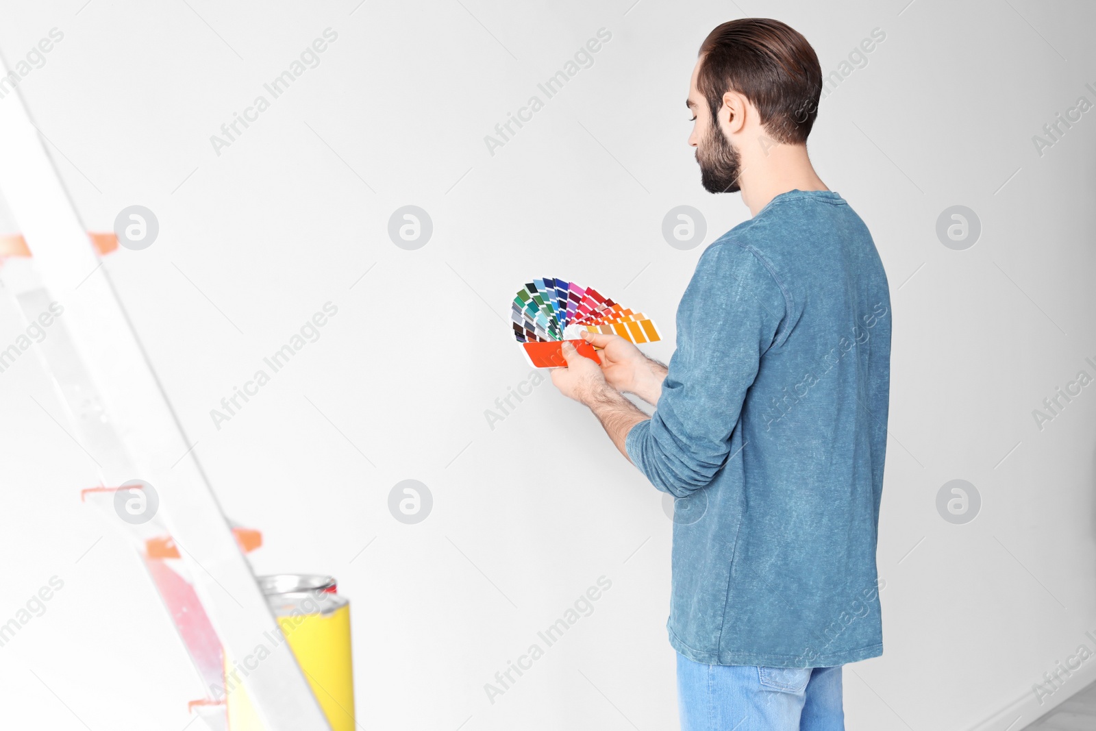 Photo of Young man with color palette on white background