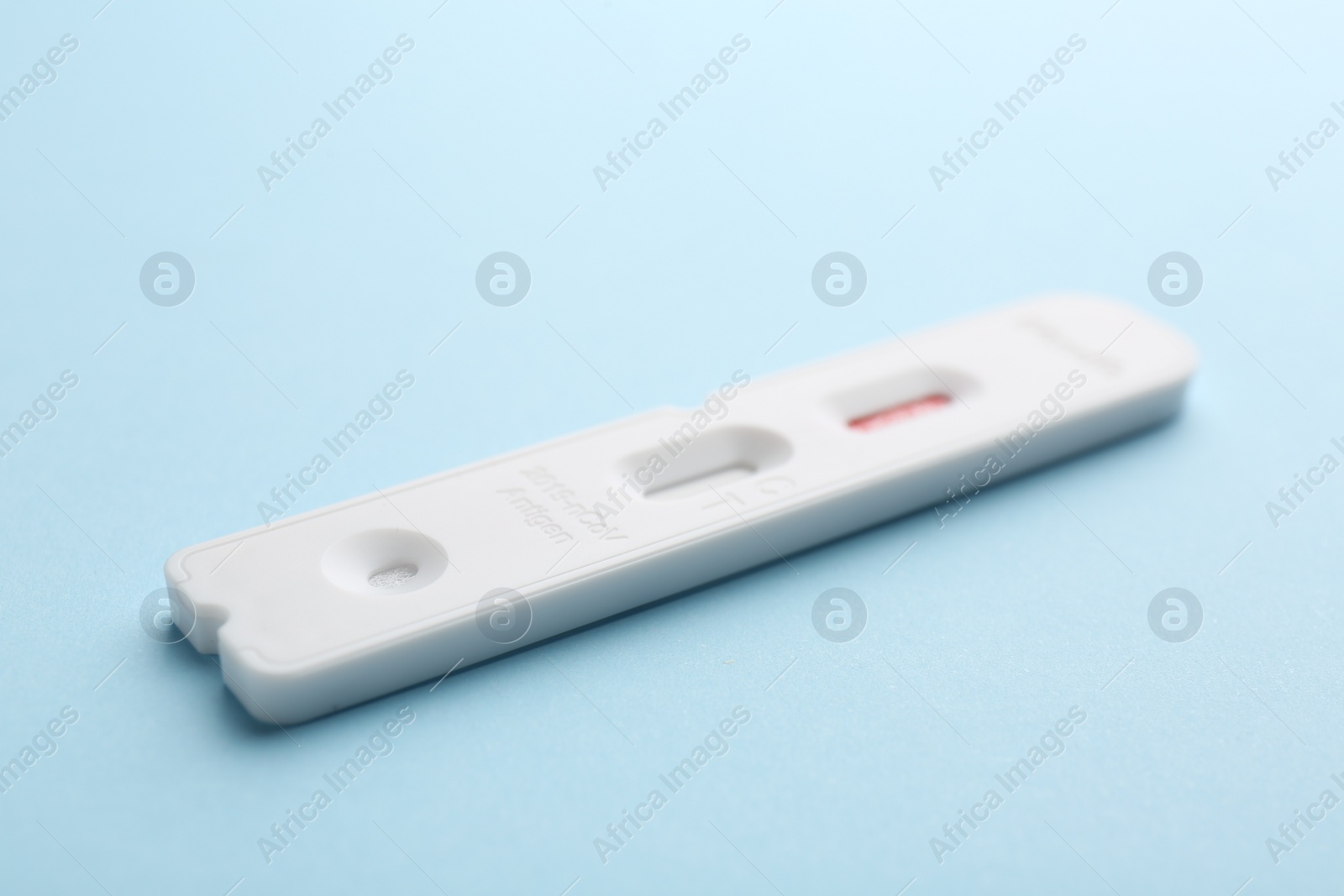 Photo of Disposable express test on light blue background, closeup