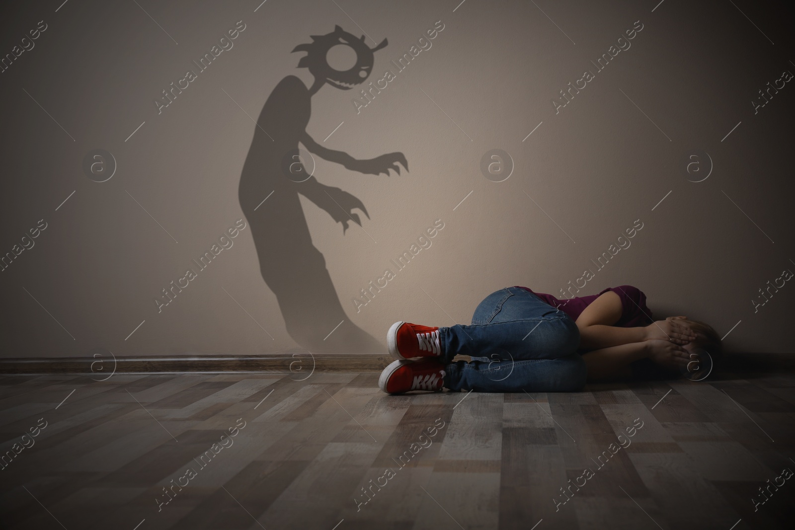 Image of Shadow of monster on wall and scared little girl in room