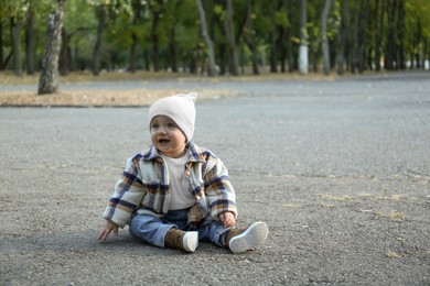 Cute little child on asphalt walkway outdoors, space for text