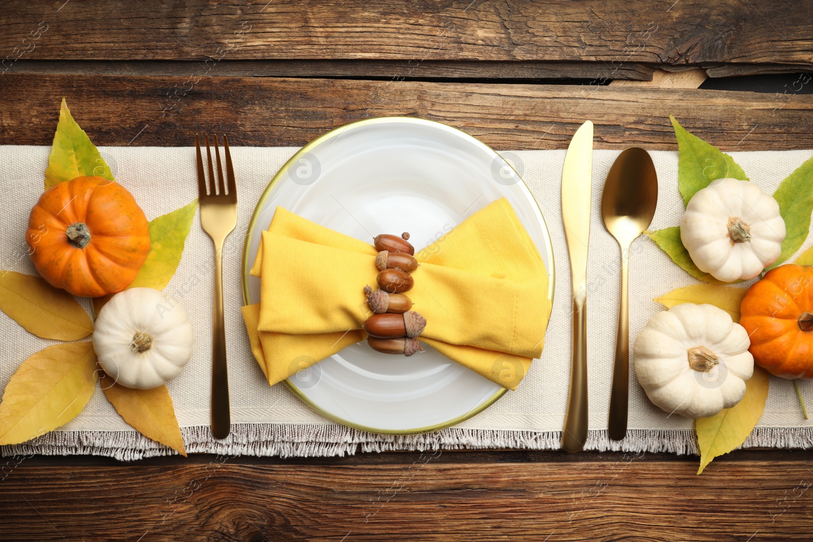 Photo of Seasonal table setting with pumpkins and other autumn decor on wooden background, flat lay