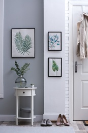 Photo of Vase with fresh eucalyptus branches on table in entryway. Interior design