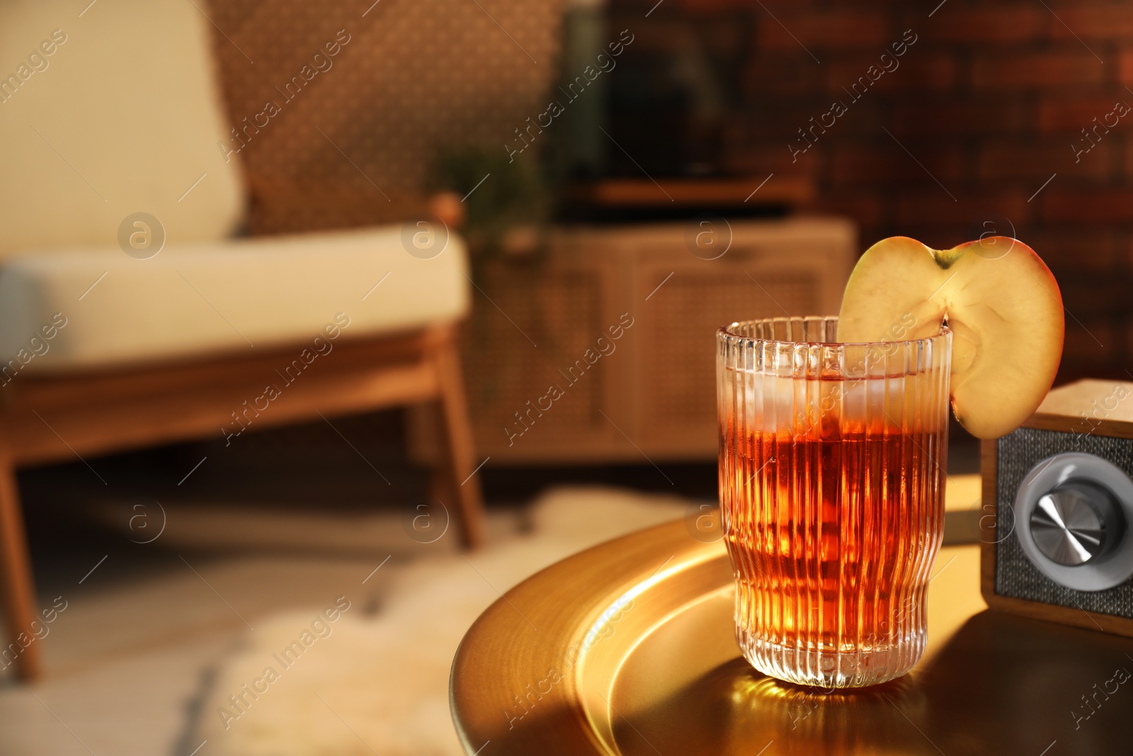 Photo of Glass of tasty cider on table in room, space for text. Relax at home