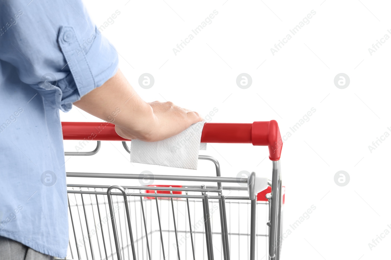 Photo of Woman holding shopping cart handle with tissue paper on white background, closeup