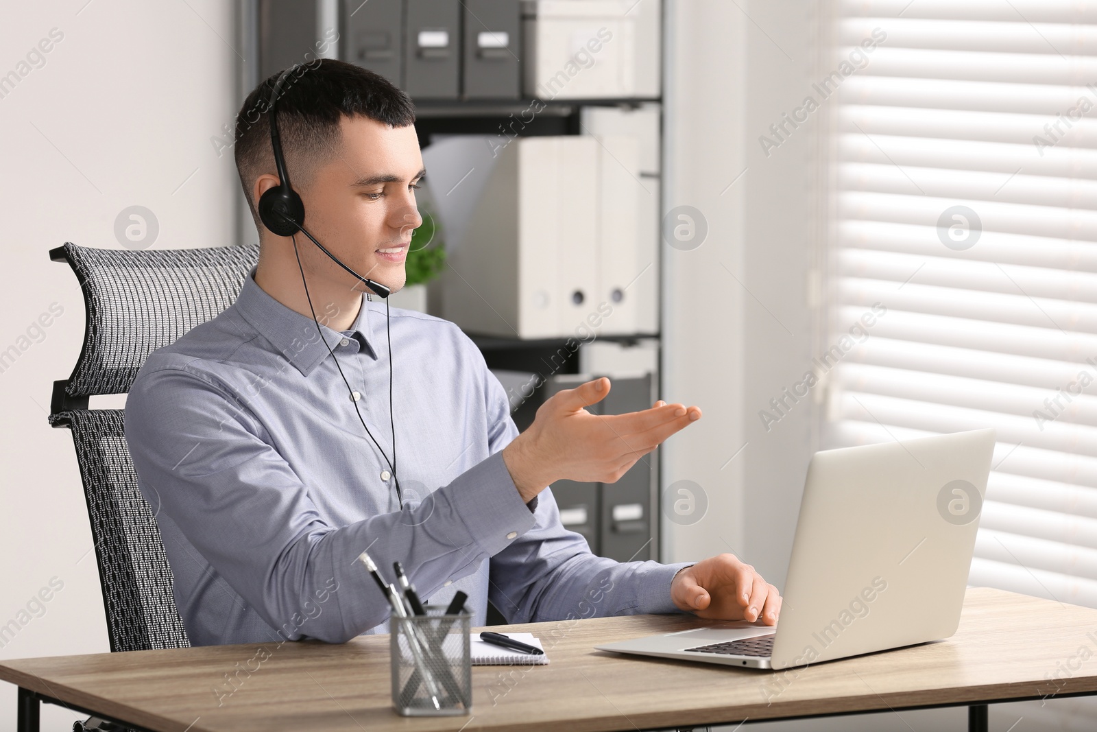 Photo of Hotline operator with headset working in office