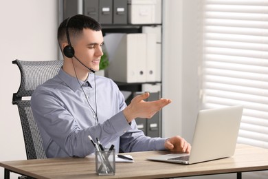 Hotline operator with headset working in office