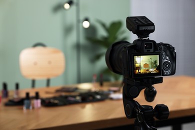 Beauty blogger's workplace. Cosmetic products on table indoors, focus on camera