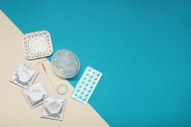 Contraceptive pills, condoms and intrauterine device on color background, flat lay and space for text. Different birth control methods