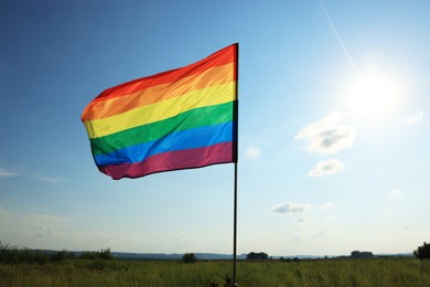 Photo of Bright LGBT flag fluttering against blue sky, space for text. Lesbian concept