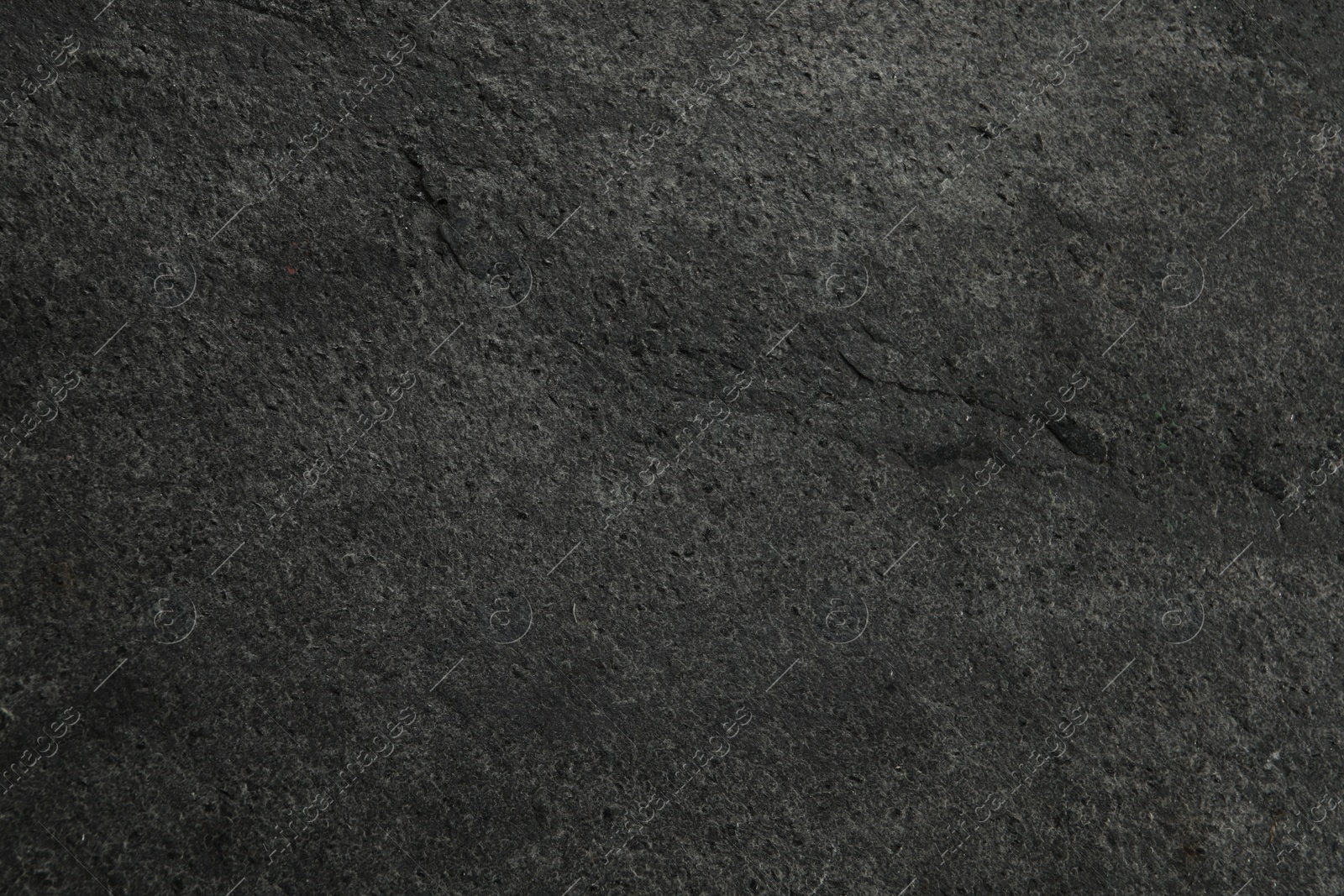 Photo of Texture of dark grey stone surface as background, closeup