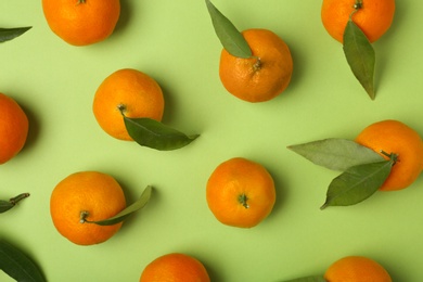 Composition with tangerines and leaves on color background, flat lay