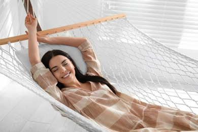 Photo of Young woman relaxing in hammock at home
