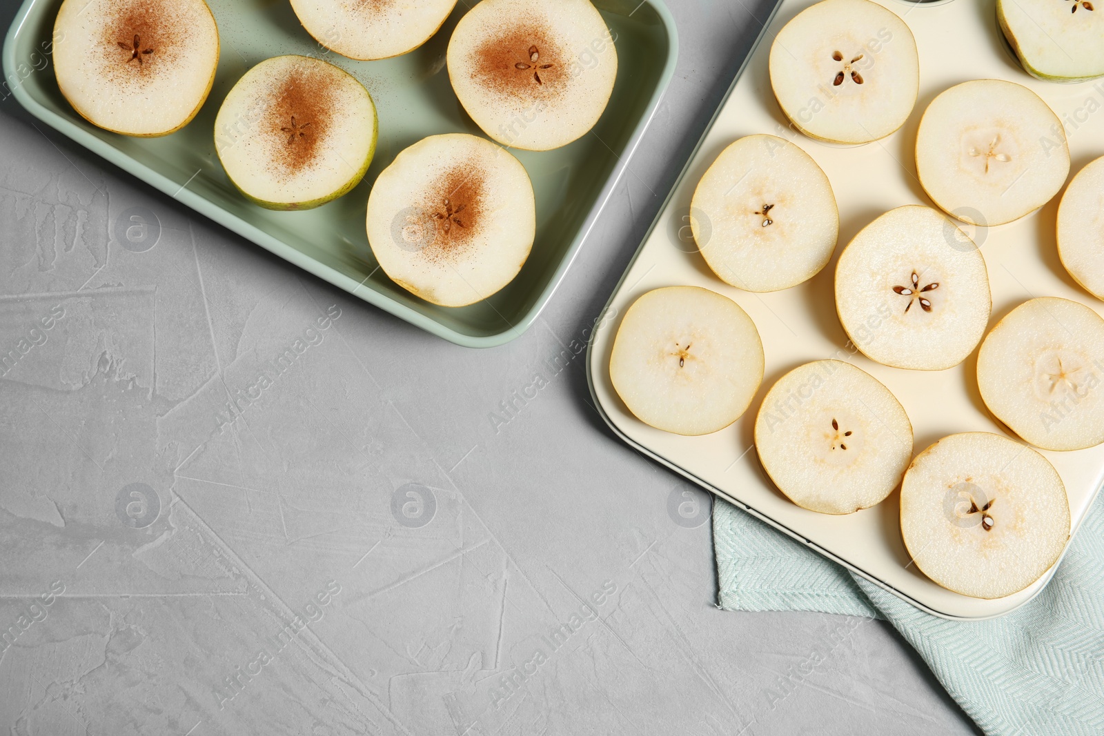 Photo of Flat lay composition with sliced fresh ripe pears, cinnamon and space for text on gray background