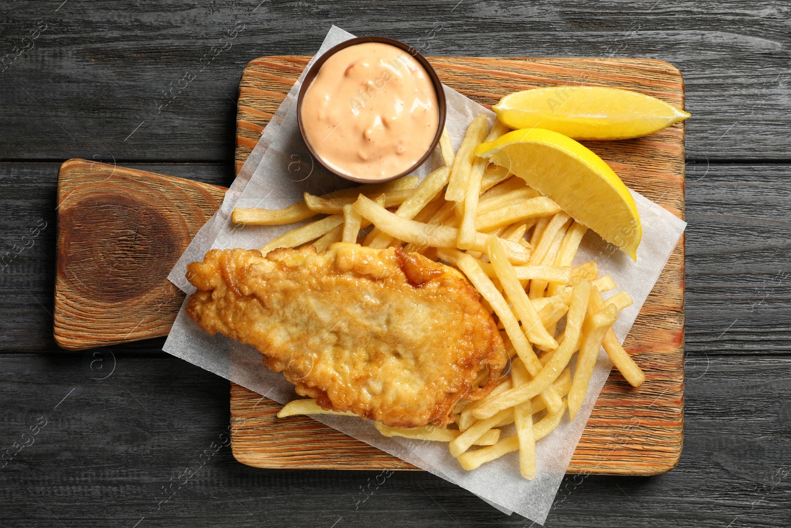 Photo of Board with British traditional fish and potato chips on wooden background, top view