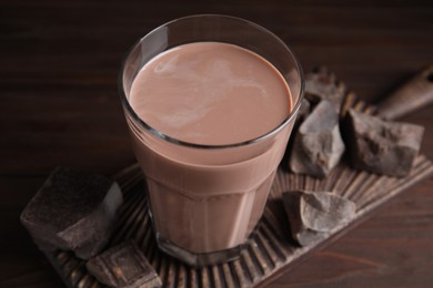 Photo of Fresh yummy chocolate milk on wooden table, closeup