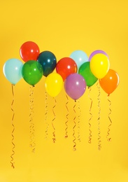 Photo of Bright balloons on color background. Celebration time