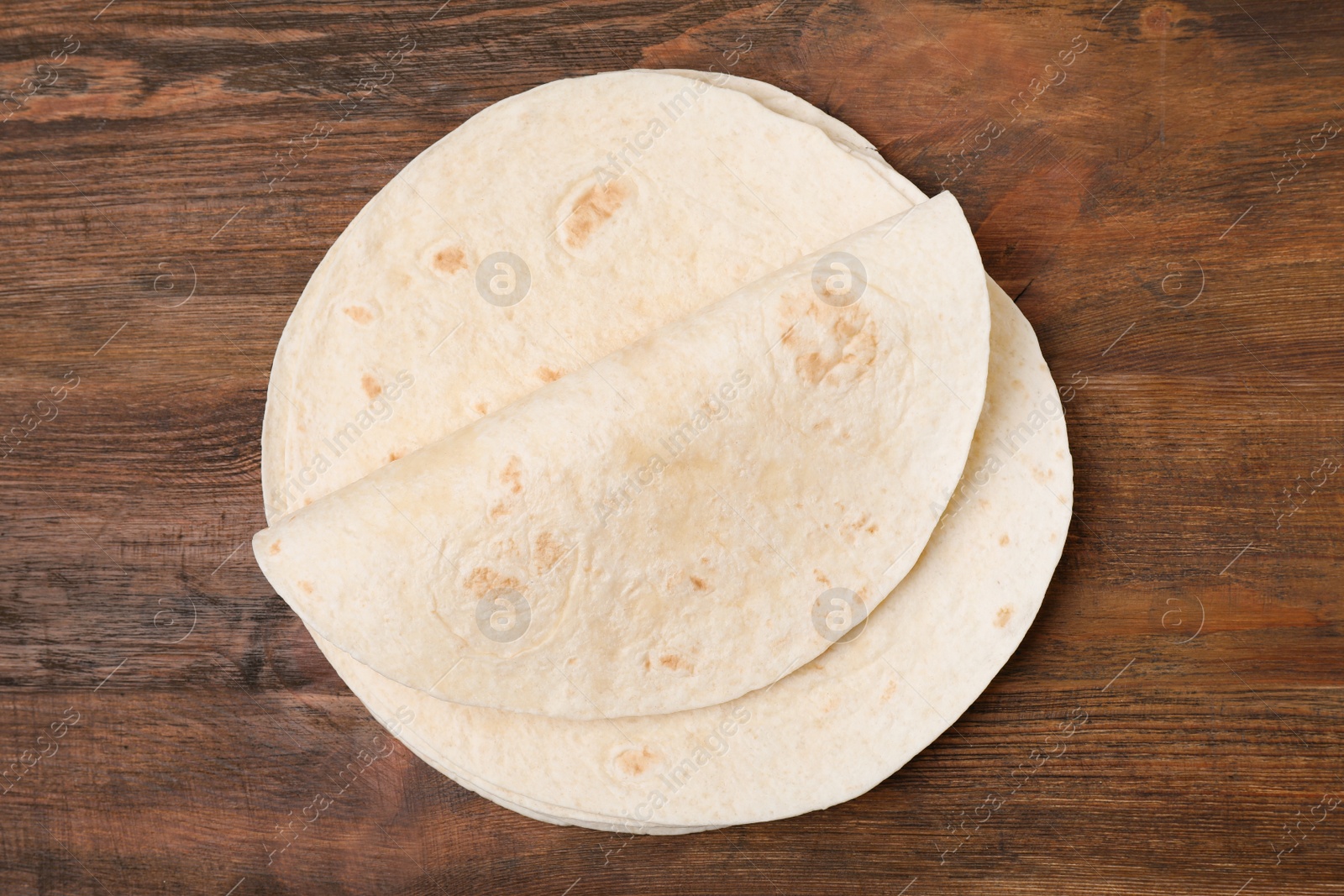 Photo of Corn tortillas on wooden background, top view. Unleavened bread