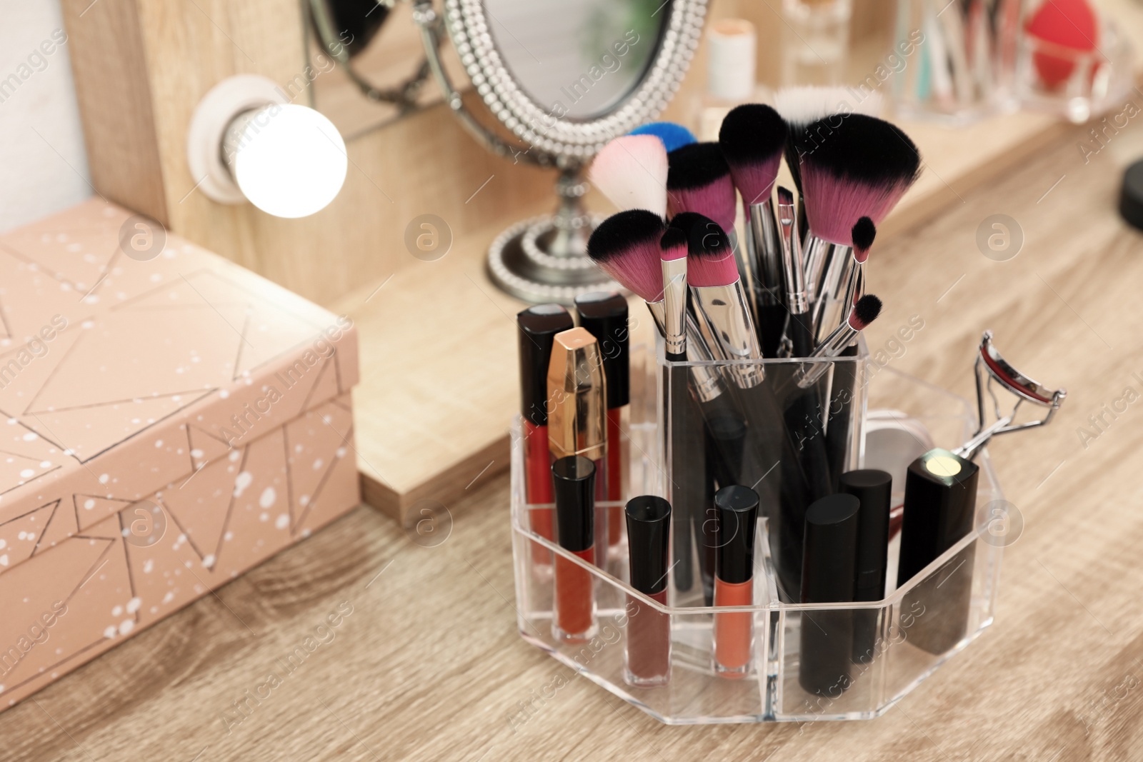 Photo of Organizer with cosmetic products for makeup on table indoors