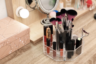 Photo of Organizer with cosmetic products for makeup on table indoors