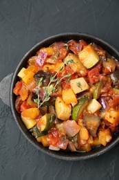 Photo of Dish with tasty ratatouille on black table, top view