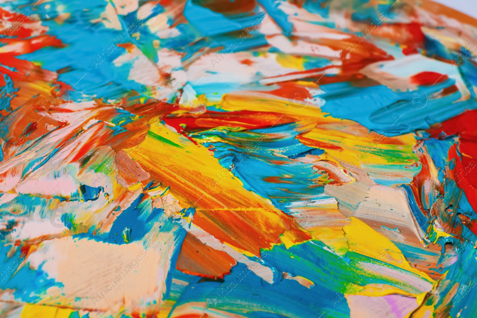 Photo of Closeup view of artist's palette with mixed bright paints as background