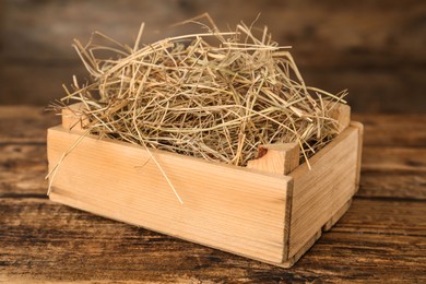 Photo of Dried hay in crate on wooden table