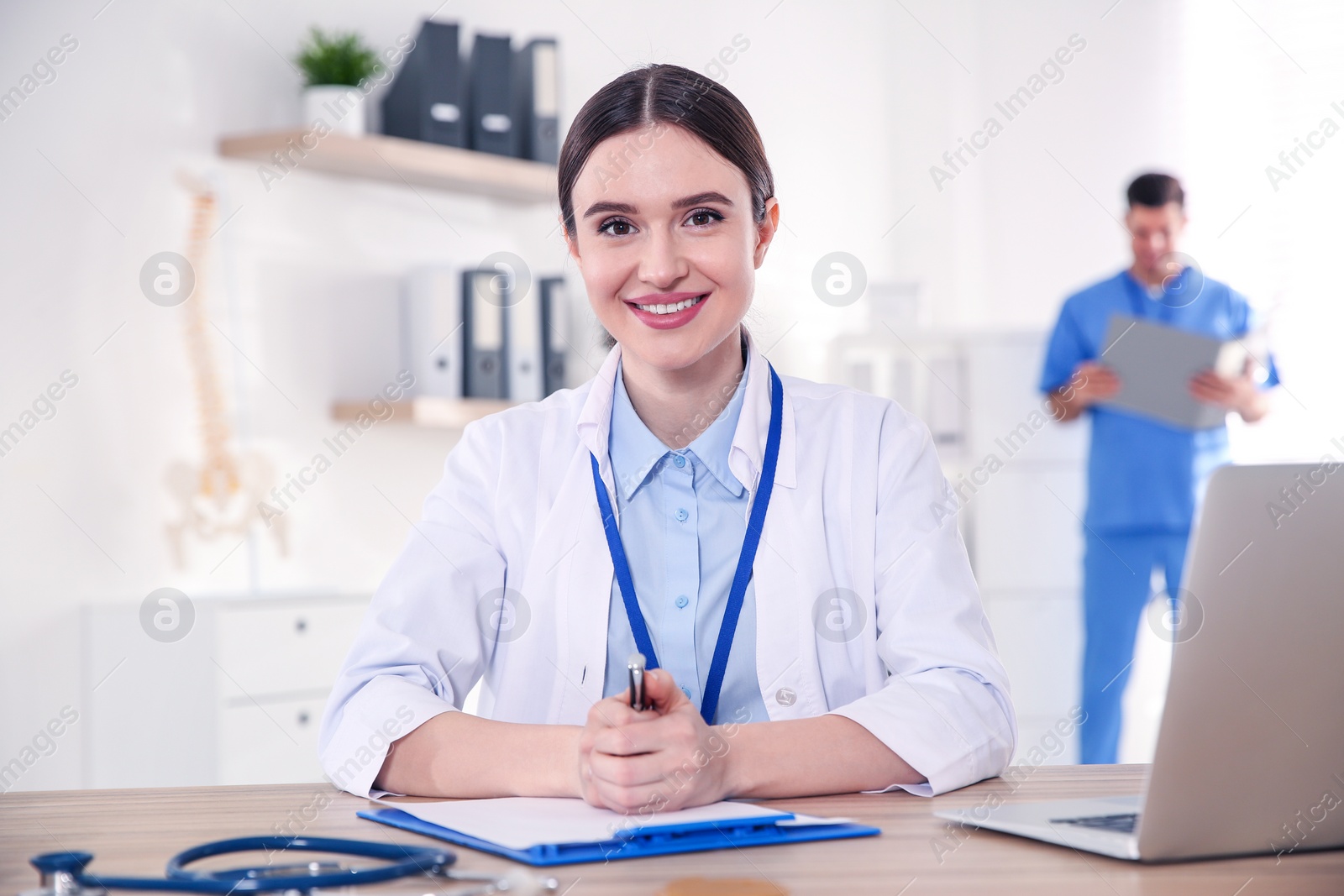 Photo of Portrait of female doctor at table in modern clinic