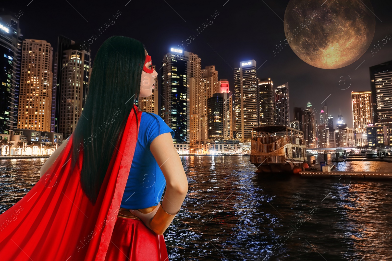 Image of Confident young woman wearing superhero costume and beautiful cityscape in night on background