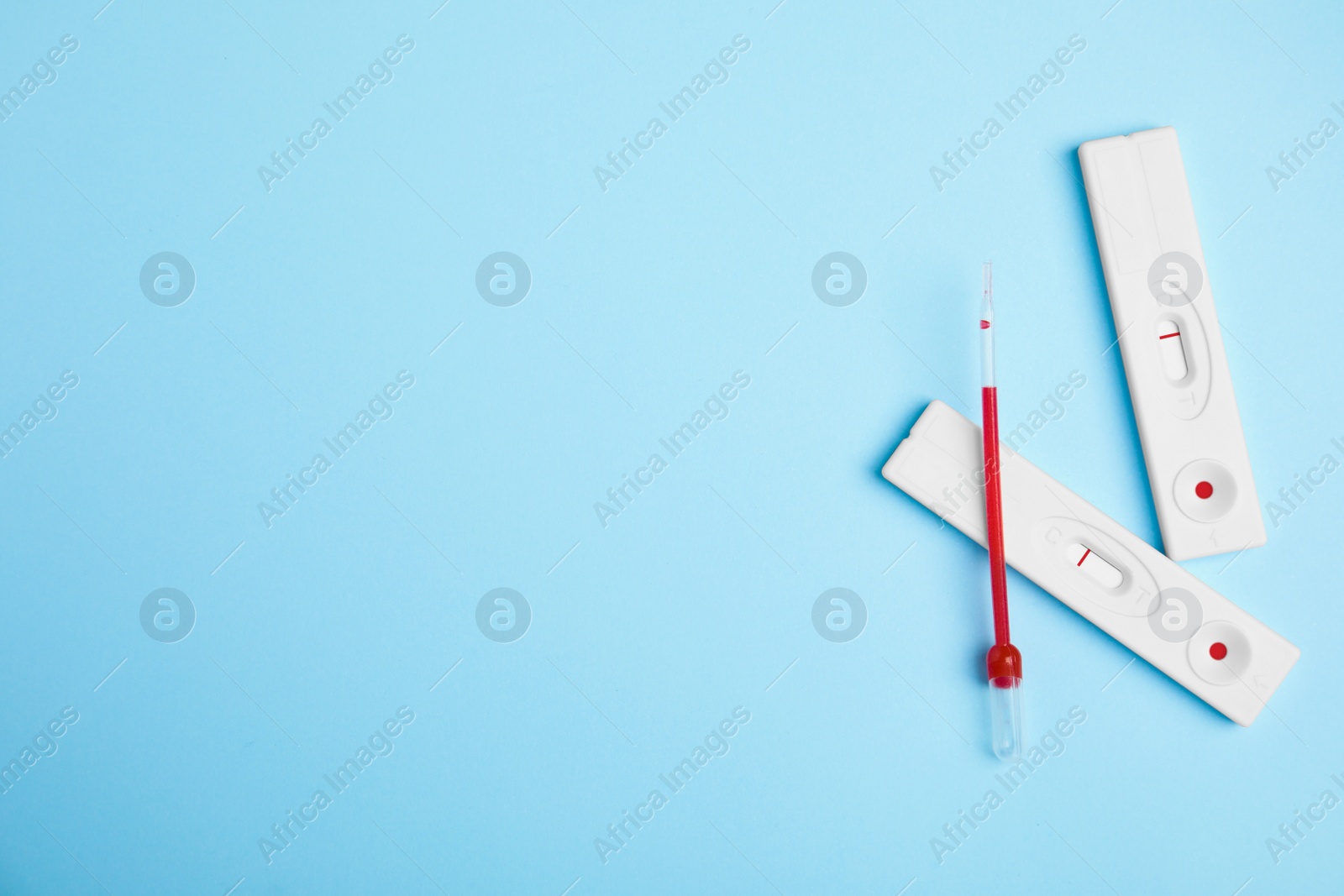 Photo of Disposable express hepatitis test kit on light blue background, flat lay. Space for text