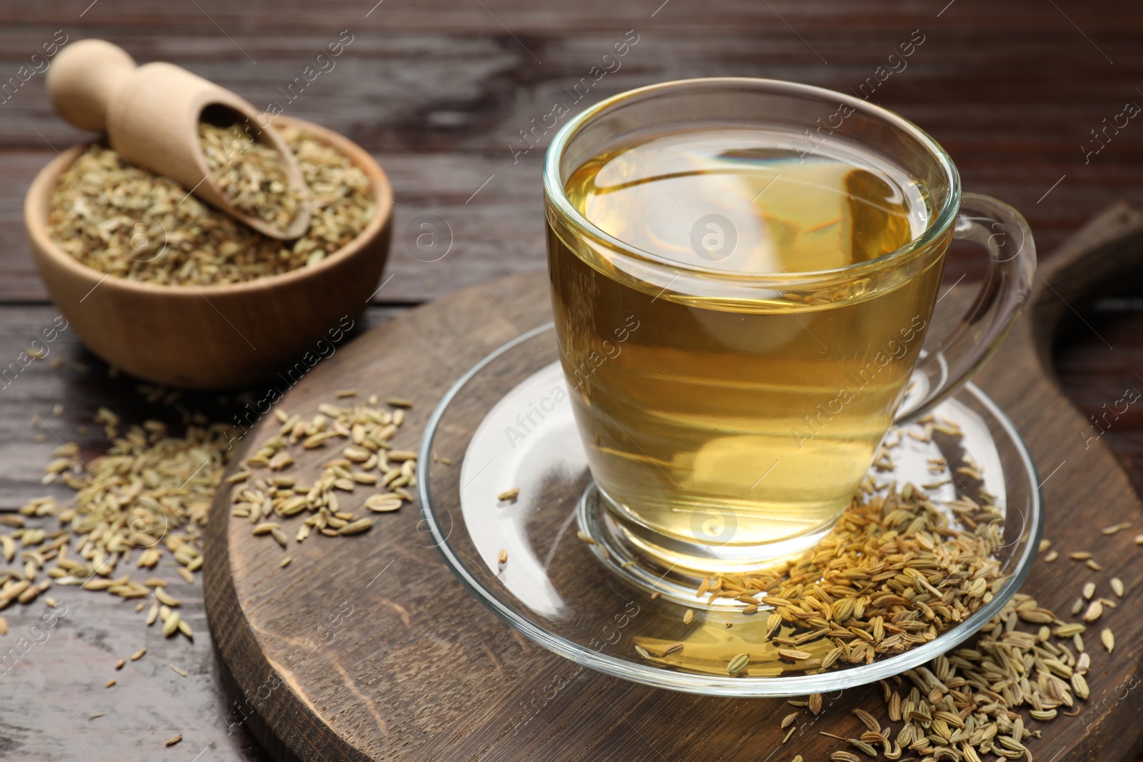 Photo of Aromatic fennel tea and seeds on wooden table, closeup. Space for text