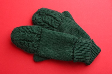 Photo of Pair of stylish woolen mittens on red background, flat lay
