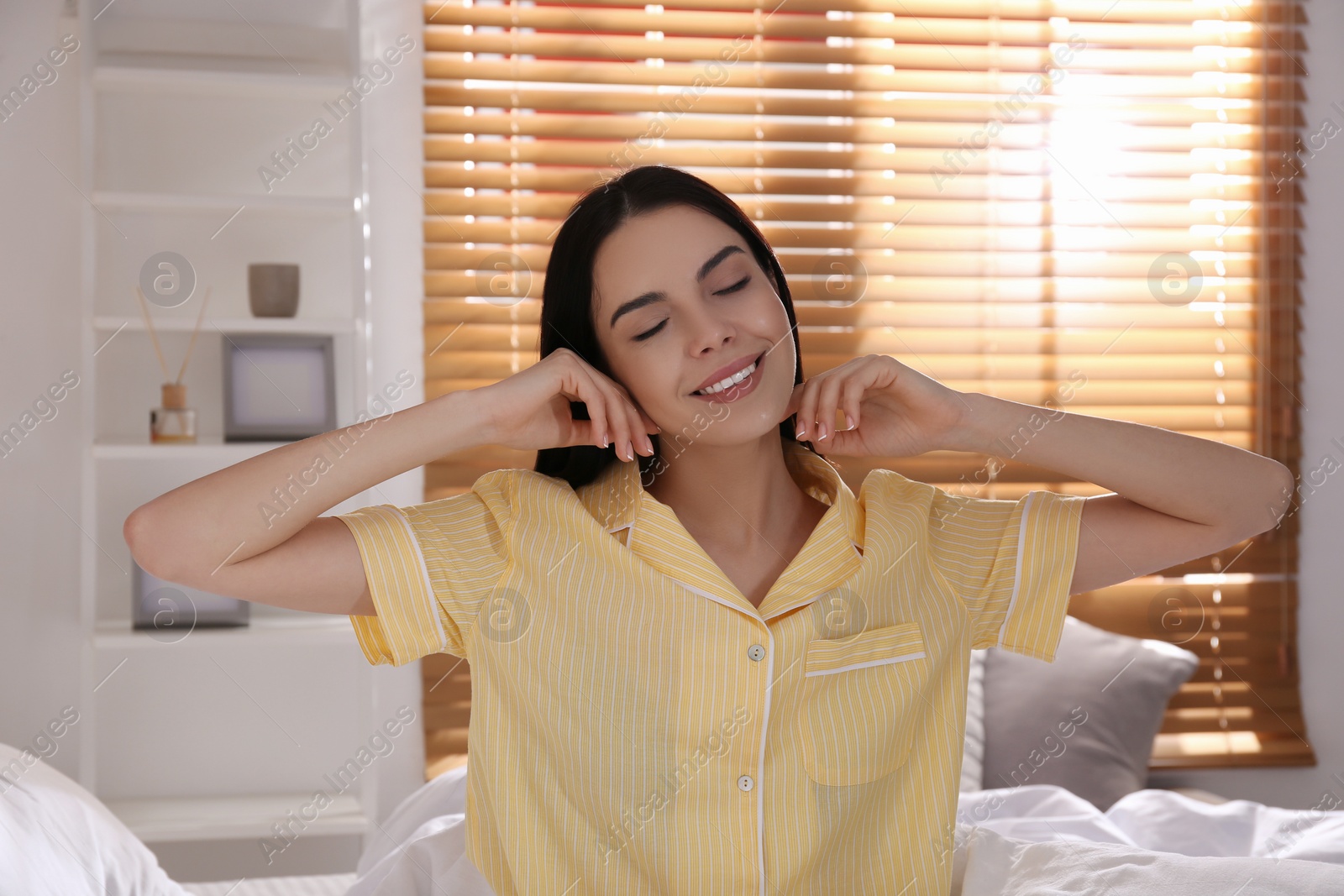 Photo of Woman sitting on comfortable bed with new linens