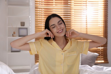 Photo of Woman sitting on comfortable bed with new linens