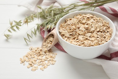 Oatmeal and branches with florets on white wooden table