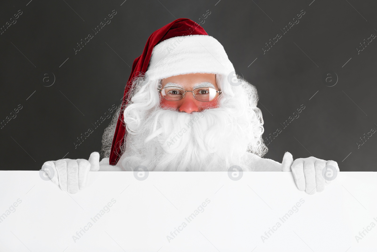 Photo of Santa Claus holding empty banner on black background
