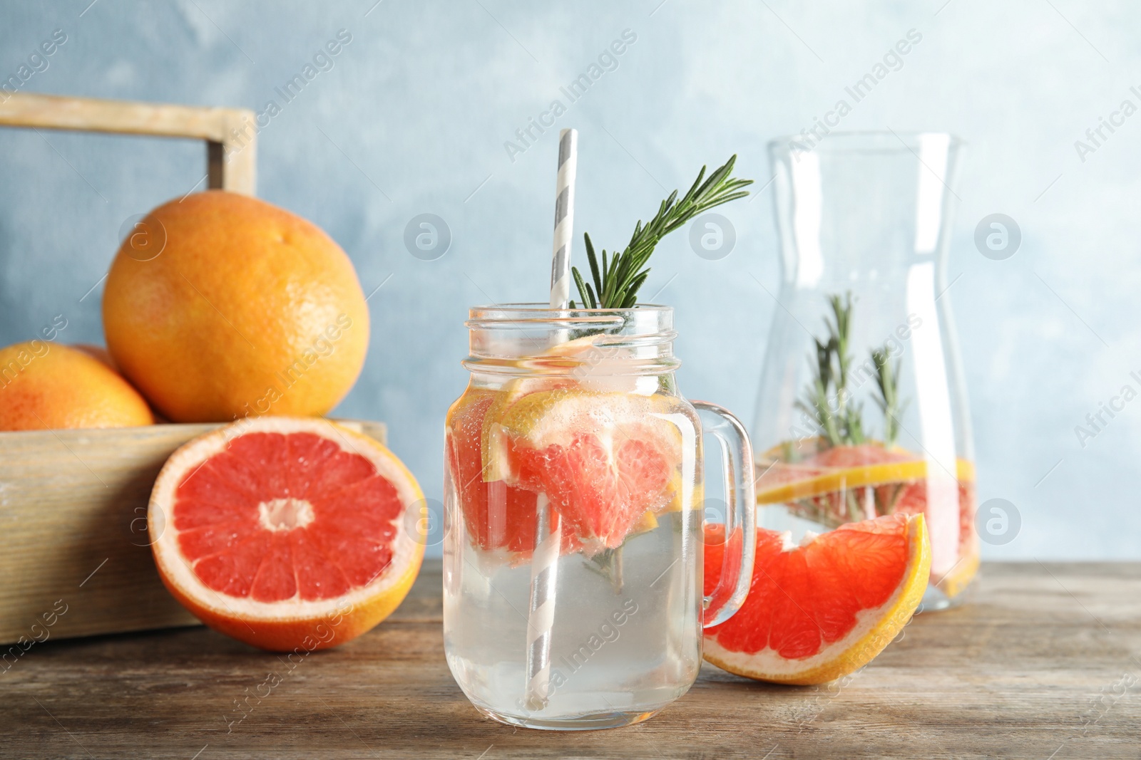 Photo of Composition with mason jar of infused water and grapefruits on table