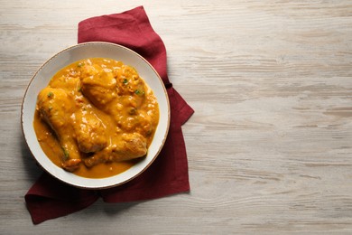 Tasty chicken curry on wooden table, top view. Space for text
