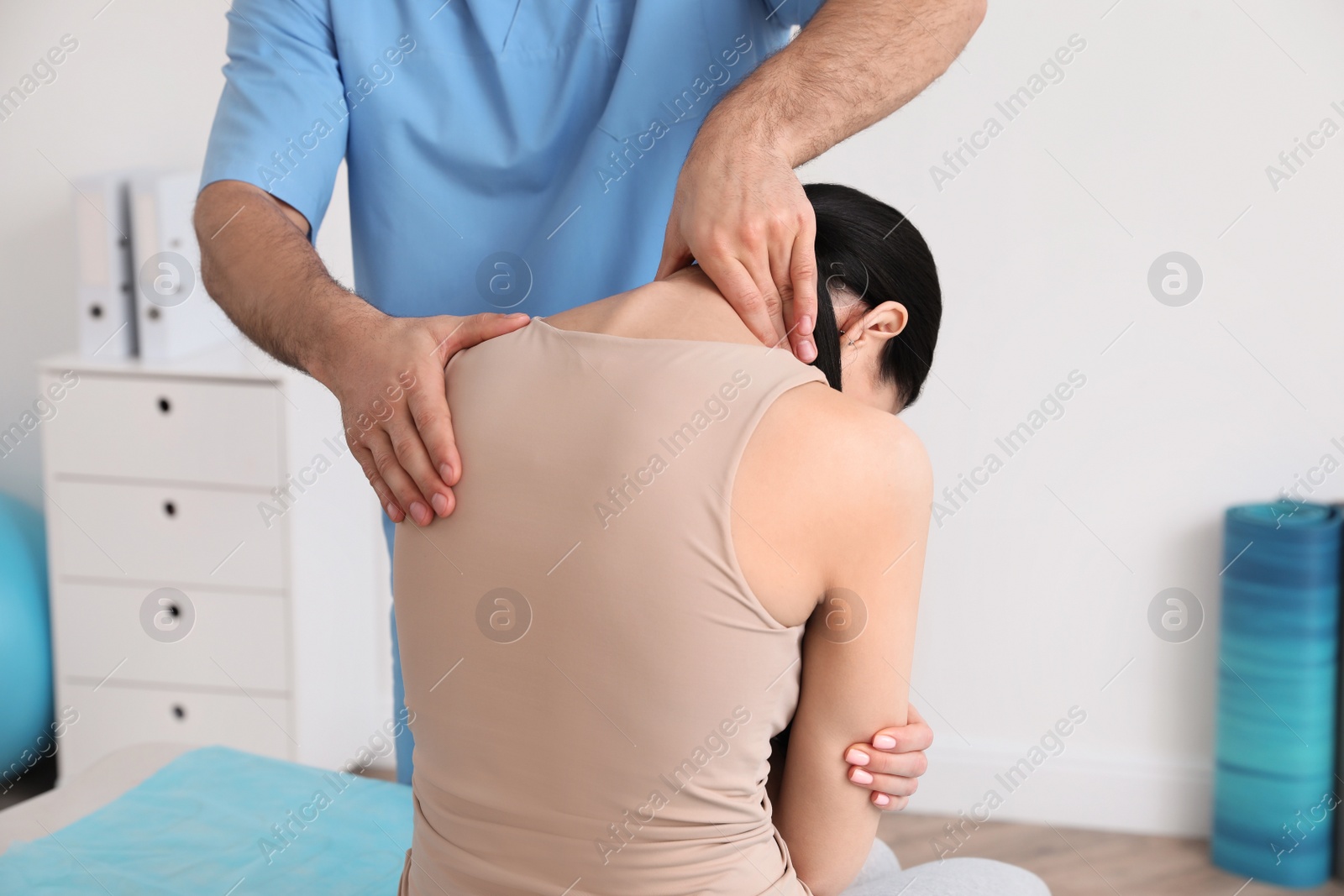 Photo of Orthopedist examining woman in clinic, closeup. Scoliosis treatment